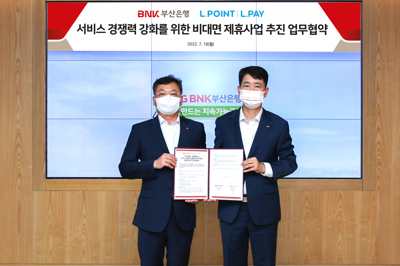 18일 부산 문현동 부산은행 본점에서 표수형 롯데멤버스 영업부문장(사진 왼쪽)과 정영준 부산은행 고객지원그룹장이 비대면 제휴사업 추진 업무협약 체결 후 기념사진을 촬영하고 있다.[롯데멤버스 제공]