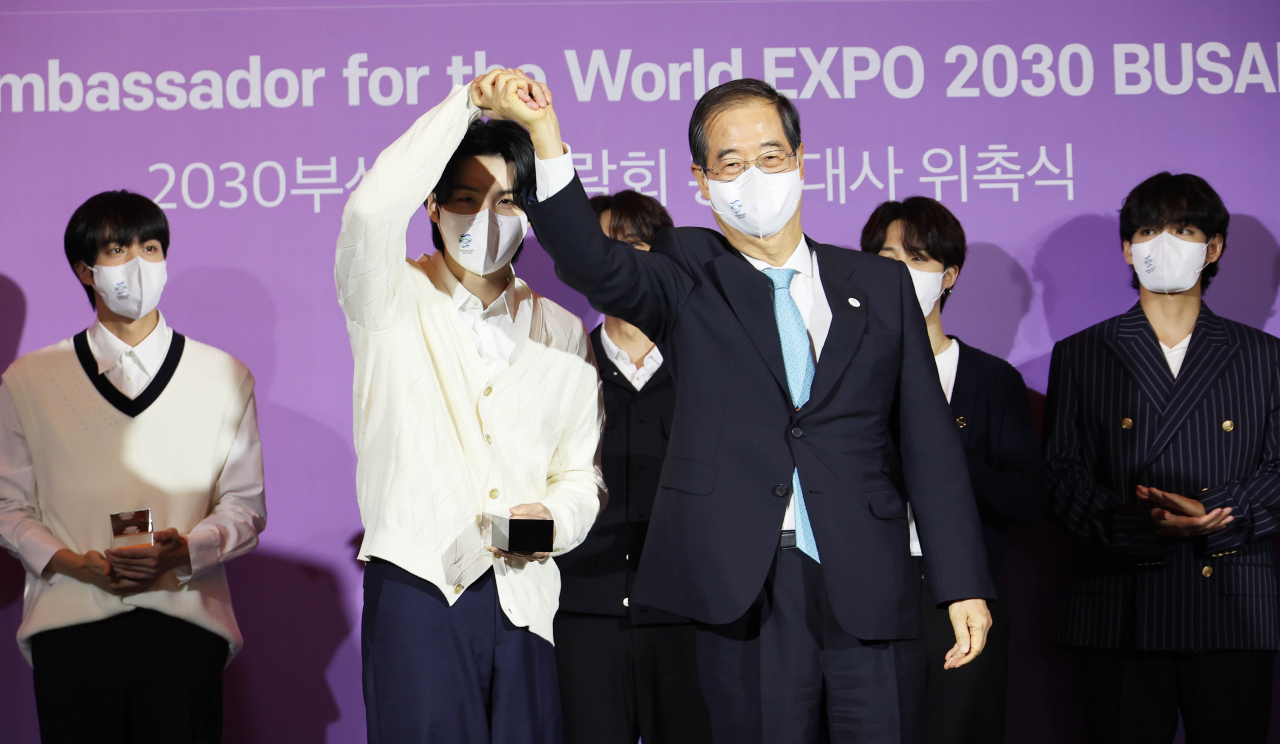 한덕수 국무총리가 19일 서울 용산구 ㈜하이브에서 열린 BTS 부산엑스포 홍보대사 위촉식에서 BTS에게 위촉패를 주고 있다.[연합]