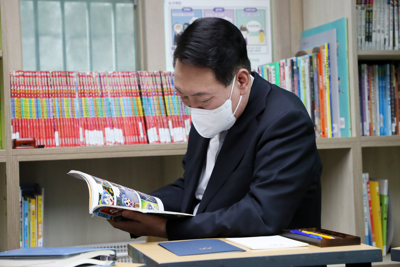 윤석열 대통령이 19일 서울 종로구 참신나는학교 지역아동센터를 방문, 센터 종사자들과의 간담회에 앞서 수학 교재를 살펴보고 있다. [대통령실통신사진기자단]