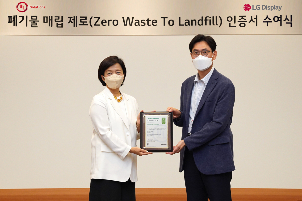 염희정(왼쪽) UL솔루션스 전무가 LG디스플레이 심규창 환경기술담당에게 인증서를 전달하고 있는 모습.[LG디스플레이 제공]