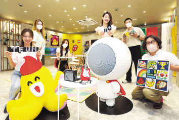 LGU+는 자사 복합문화공간 ‘틈’에서 글로벌 완구 브랜드 레고(LEGO) 창립 90주년 기념 전시를 진행한다고 20일 밝혔다. LGU+ 모델들이 홀맨, 무너 등 자사 대표 캐릭터 레고 모형과 함께 전시를 소개 중이다. [LGU+ 제공]