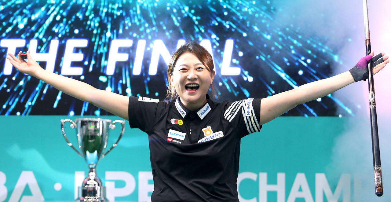 우승컵을 뒤에 세워둔 김민아가 활짝 웃으며 양팔을 펼치는 세리머니를 하고 있다. [PBA 제공]