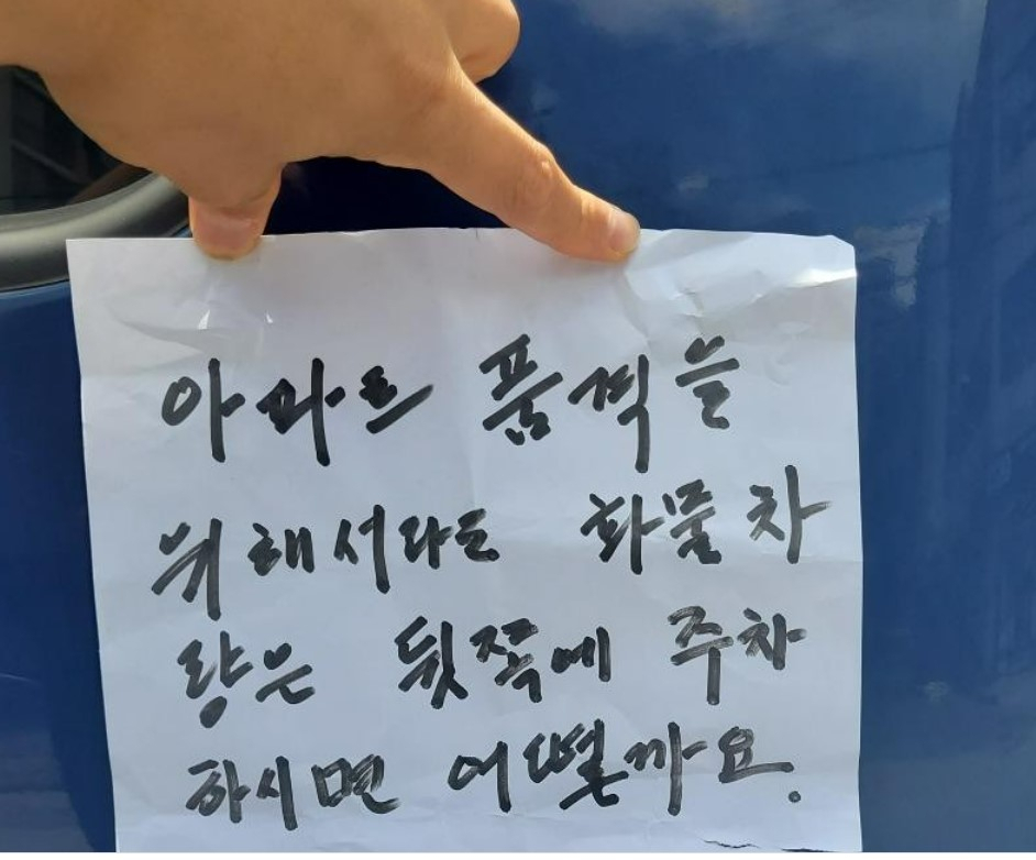 화물차주가 아파트 주민에게 받은 쪽지를 펼쳐 보이고 있다. [온라인 커뮤니티]