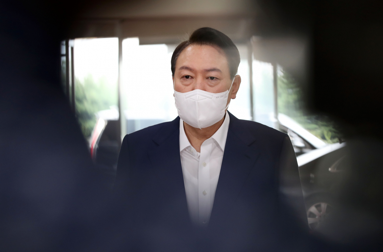 President Yoon Suk-yeol takes reporters' questions as he arrives at the presidential office in Seoul on Friday. (Yonhap)
