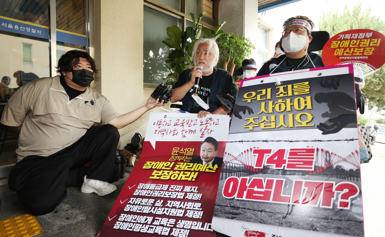 박경석(왼쪽) 전국장애인차별철폐연대(전장연) 상임공동대표가 지난 19일 오전 서울 용산경찰서에서 열린 ‘전장연 경찰 조사 자진출석·김광호 서울경찰청장 법 준수 촉구 기자회견’에서 발언하고 있다. [연합]
