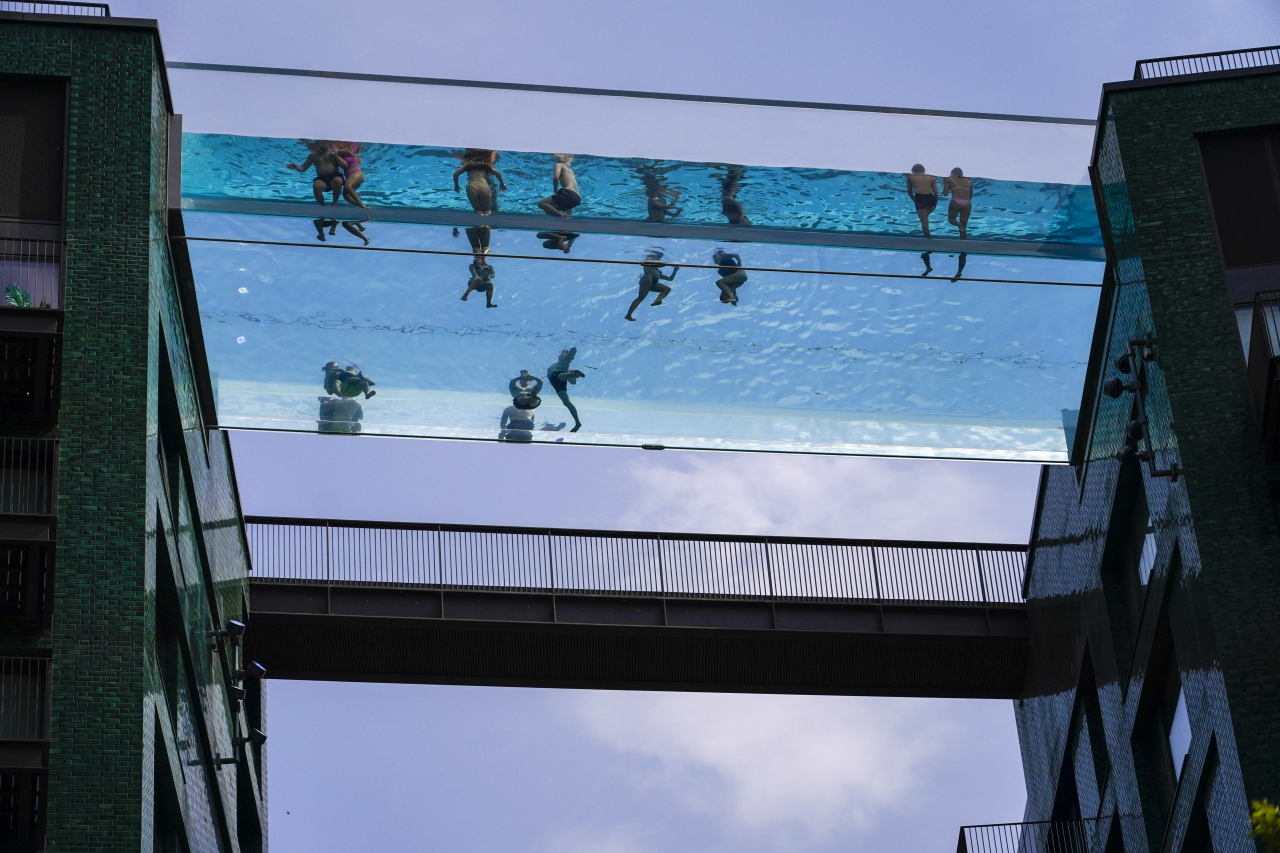 스카이풀(pool)로 불리기도 하는 런던 엘리베이터 풀에서 사람들이 수영을 즐기고 있다. 입국 규제를 완전히 철폐한 영국은 요즘 성수기임에도 전례없는 폭염경보로 혼란을 겪고 있다. [AP]