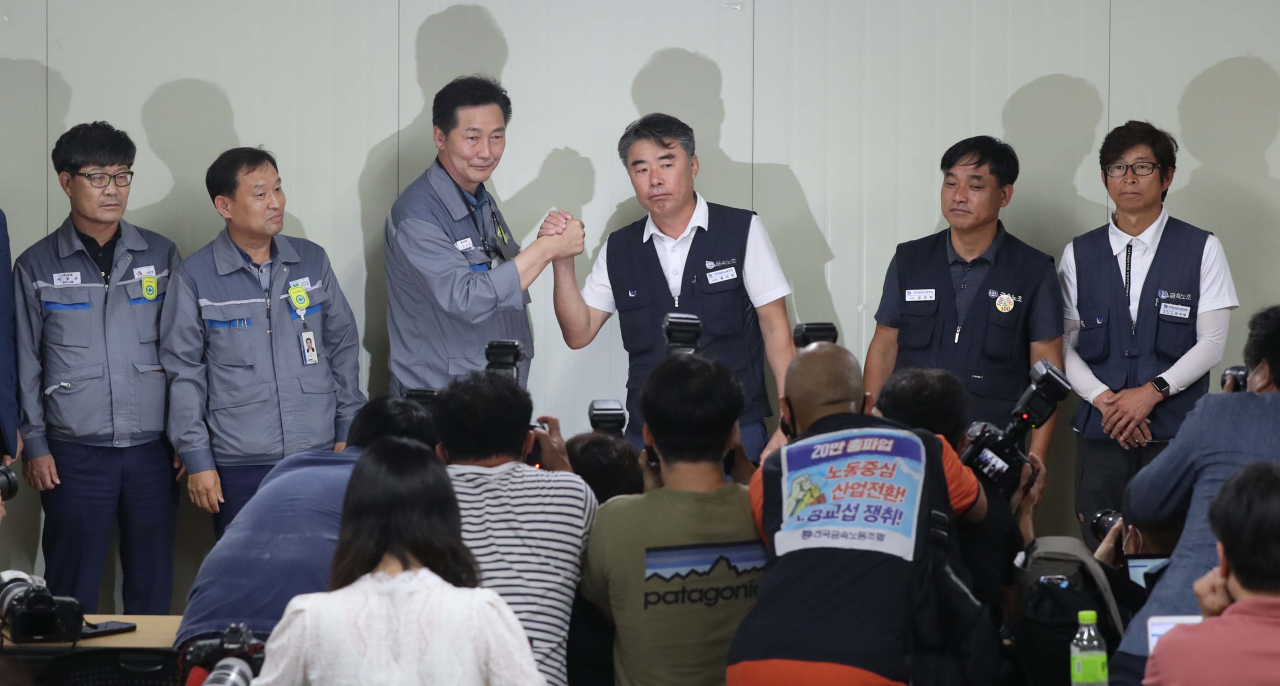 대우조선해양 하청 노사협상이 극적으로 타결된 22일 경남 거제시 대우조선해양 옥포조선소에서 협력사 대표들과 하청노조 조합원들이 악수하고 있다. 왼쪽 세 번째부터 권수오 녹산기업 대표, 홍지욱 금속노조 부위원장, 윤장혁 금속노조 위원장. [연합]