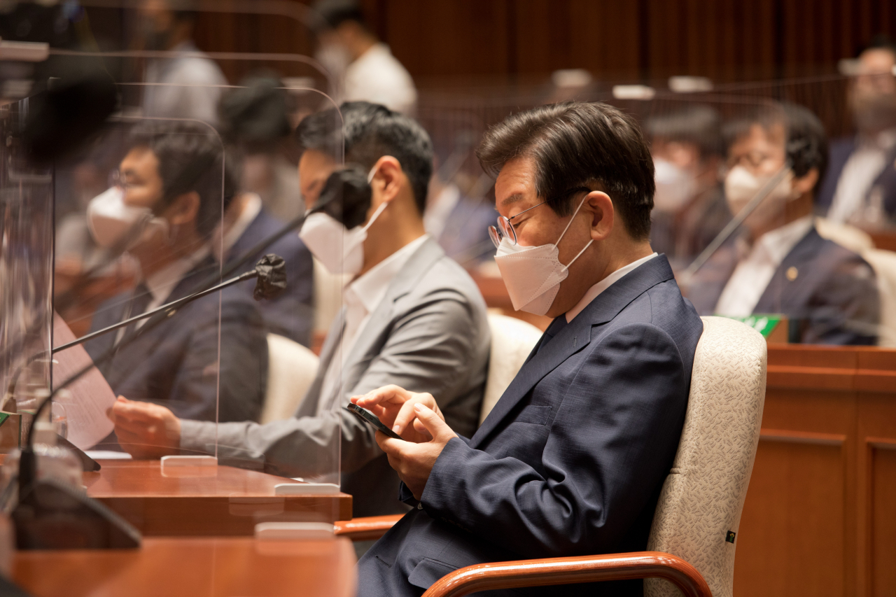 전당대회 당대표에 출마한 더불어민주당 이재명 의원이 22일 국회 본청 예결위회의장에서 열린 의원총회에 참석, 휴대전화를 보고 있다. [연합]