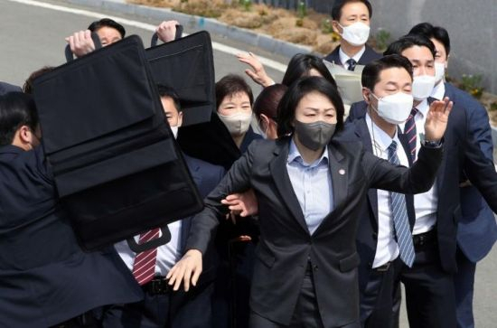 지난 3월 박근혜 전 대통령이 대구 달성군 사저에 도착해 대국민 담화문을 밝히던 중 갑자기 소주병이 날아들자 경호원들이 박 전 대통령을 보호하고 있다. [연합뉴스]