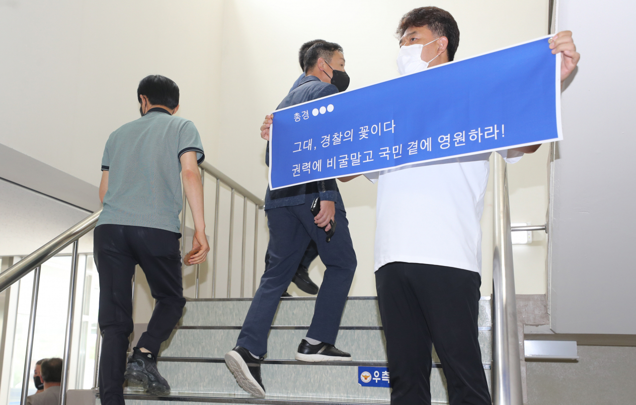 23일 오후 2시 전국 경찰서장 회의가 열리는 충남 아산 경찰 인재개발원 안에서 한 경찰관이 플래카드를 들고 참가자들을 응원하고 있다. [연합]