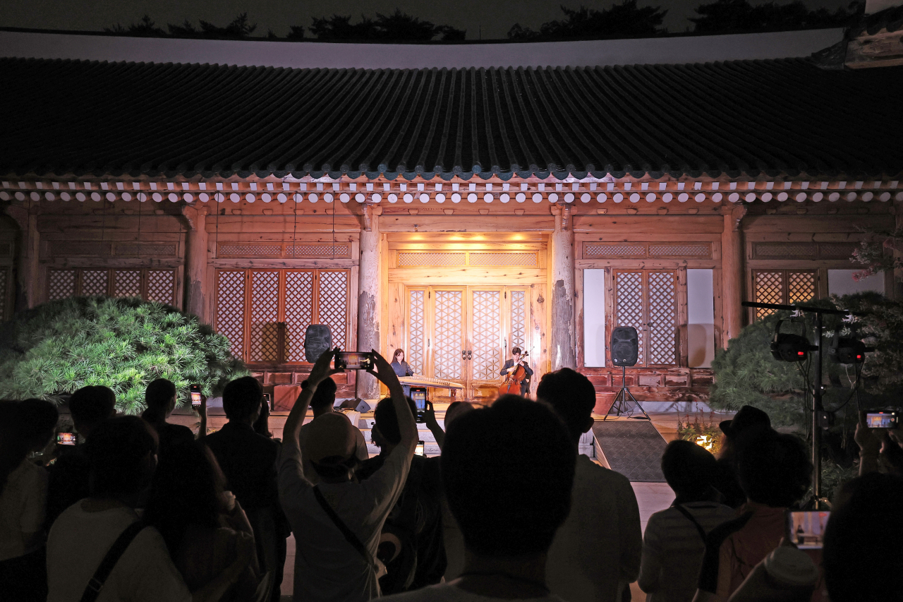 20일 청와대 야간 개방 행사인 '청와대 한여름 밤의 산책' 행사에 참여한 시민들이 관저에서 퓨전 국악공연을 관람하고 있다. [연합]