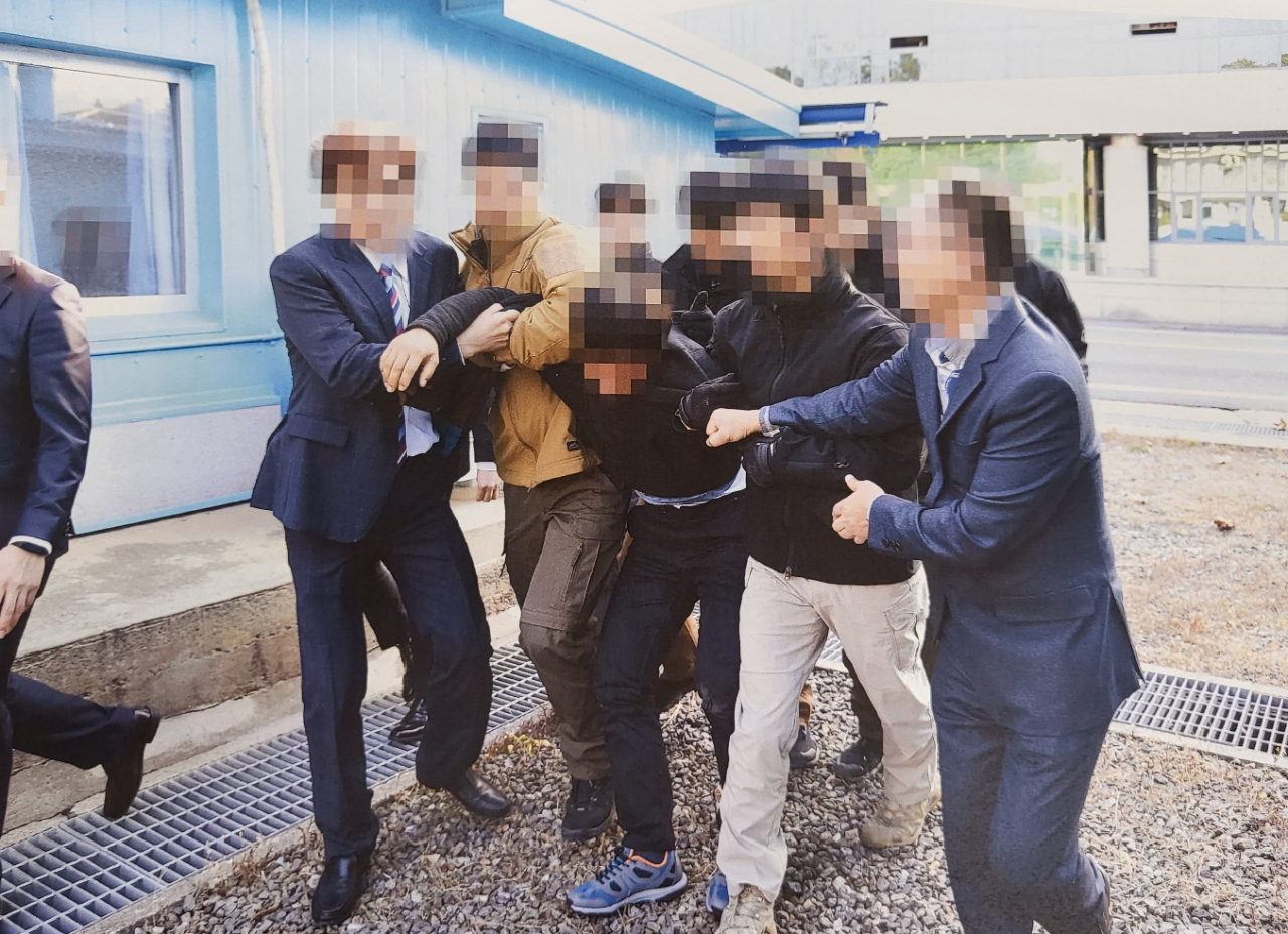 통일부는 지난 2019년 11월 판문점에서 탈북어민 2명을 북한으로 송환하던 당시 촬영한 사진을 12일 공개했다. 당시 정부는 북한 선원 2명이 동료 16명을 살해하고 탈북해 귀순 의사를 밝혔으나 판문점을 통해 북한으로 추방했다. 사진은 탈북어민이 몸부림치며 북송을 거부하는 모습. [연합]
