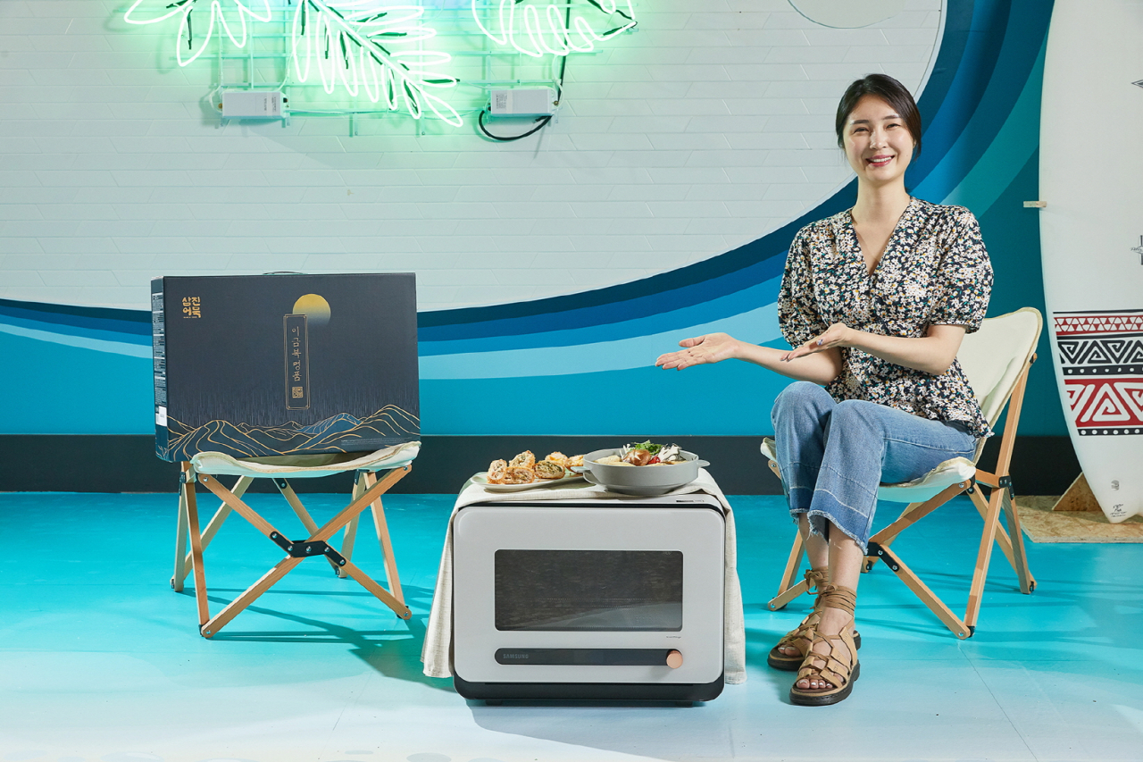 삼성전자 모델이 삼진어묵 부산역광장점에서 비스포크 큐커와 이금복 명품세트를 비롯한 삼진어묵 제품을 소개하고 있는 모습.[LG디스플레이 제공]