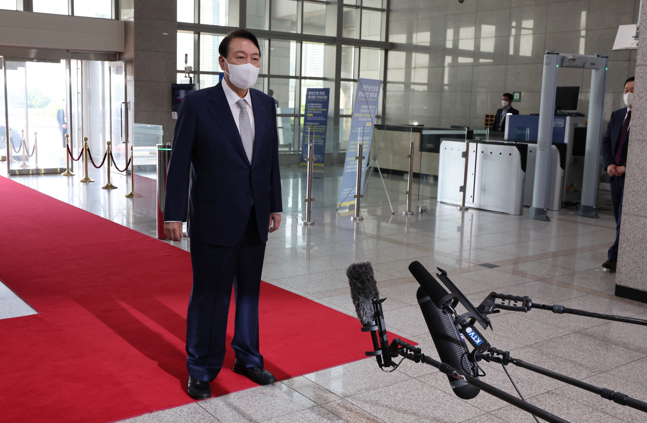 President Yoon Suk-yeol takes reporters' questions as he arrives at the presidential office in Seoul on Tuesday. (Yonhap)