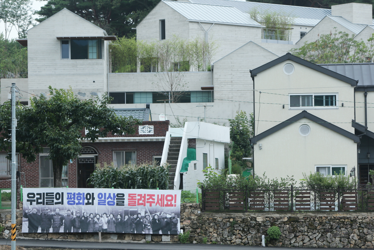 경남 양산시 하북면 지산리 평산마을 문재인 전 대통령 사저 앞에 '우리들의 평화와 일상을 돌려주세요'라고 적힌 현수막이 걸려 있다. [연합]