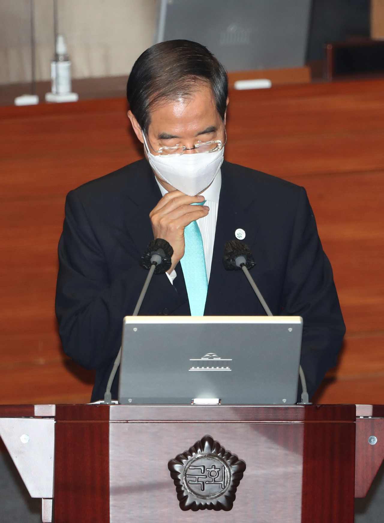 한덕수 국무총리가 27일 오후 서울 여의도 국회 본회의장에서 열린 교육·사회·문화 분야 대정부질문에서 더불어민주당 한정애 의원의 질문에 답하며 마스크를 매만지고 있다. 이상섭 기자