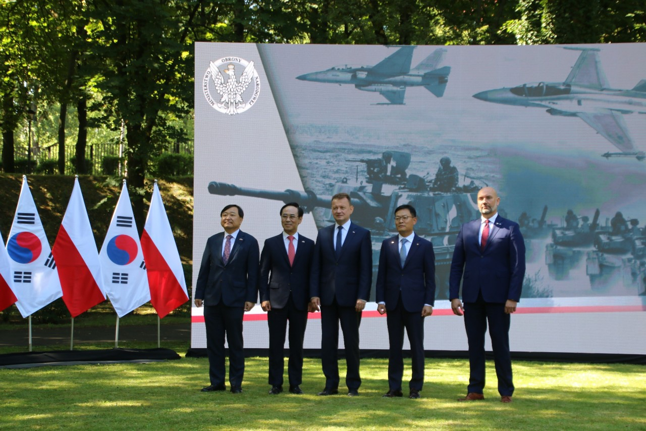 폴란드와 한국 방산업체들이 27일(현지시간) 바르샤바 국방부 본부에서 FA-50 경공격기와 K2전차, K9자주포 등을 도입하는 기본계약을 체결한 뒤 하고 기념사진을 촬영하고 있다. 왼쪽부터 안현호 한국항공우주산업(KAI) 대표, 이용배 현대로템 대표, 마리우시 브와슈차크 폴란드 부총리 겸 국방부장관, 손재일 한화디펜스 대표, 세바스찬 흐바워크 국영방산기업 PGZ 회장. [국방부 공동취재단]