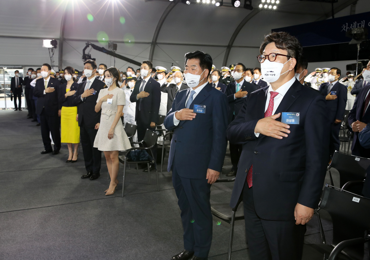 권성동 국민의힘 당대표 직무대행 겸 원내대표가 28일 오전 울산시 현대중공업에서 열린 차세대 이지스구축함 정조대왕함 진수식에서 국기에 경례를 하고 있다. [연합]