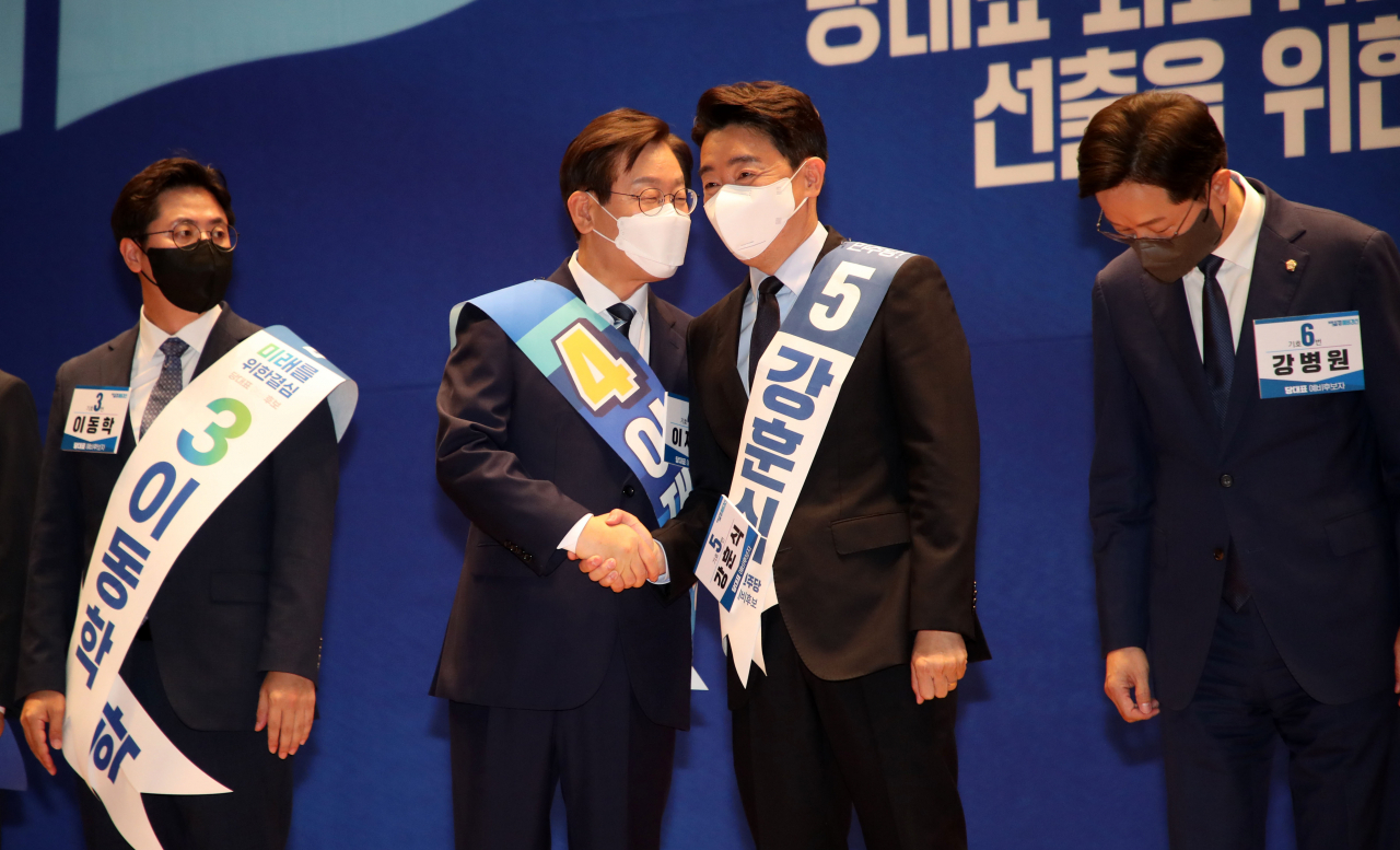 더불어민주당 강훈식(오른쪽에서 두번째) 당대표 예비후보가 28일 서울 여의도 국회 의원회관에서 열린 당대표 및 최고위원 선출을 위한 예비경선대회에서 이재명 예비후보와 악수하고 있다. [연합]
