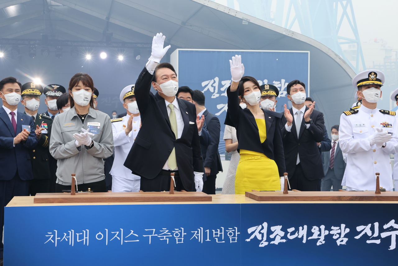 윤석열 대통령과 김건희 여사가 28일 오전 울산시 현대중공업에서 열린 차세대 이지스구축함 정조대왕함 안전항해 기원식을 마친 뒤 장병들을 향해 손을 흔들고 있다. [연합]