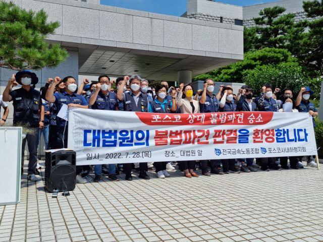 포스코 협력업체 직원들이 지난 28일 포스코를 상대로 낸 근로자 지위 확인 소송에서 최종 승소 판결을 받고 사진을 촬영하고 있다. [포스코사내하청지회 제공]