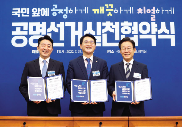 더불어민주당 당대표 선거 본경선에 오른 강훈식(왼쪽부터)·박용진·이재명 후보가 29일 국회에서 열린 당 대표 및 최고위원 후보자 공명선거실천 협약식에서 기념촬영을 하고 있다. 이상섭 기자