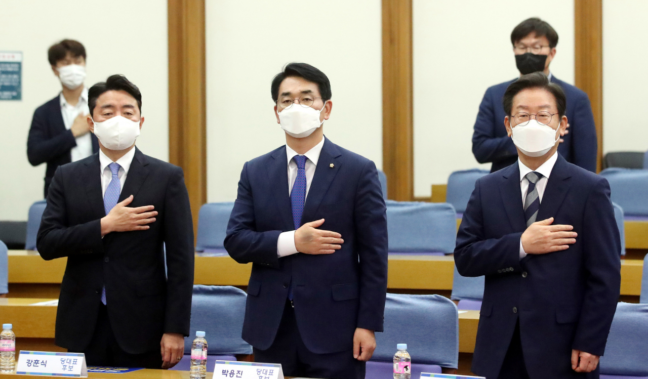 더불어민주당 강훈식(왼쪽부터), 박용진, 이재명 당 대표 후보가 29일 오전 국회 의원회관에서 열린 더불어민주당 국민통합 정치교체 추진위원회 당 대표 후보자 초청 공개토론회에서 국민의례를 하고 있다. [연합]