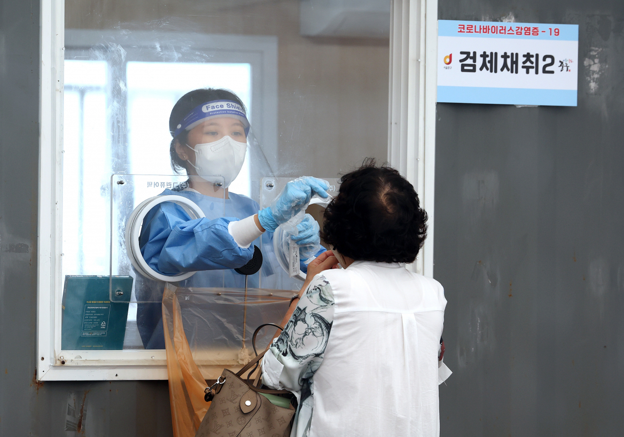 [사진=31일 오후 서울역광장에 마련된 임시선별검사소에서 의료진이 검체를 채취하고 있다.][연합]