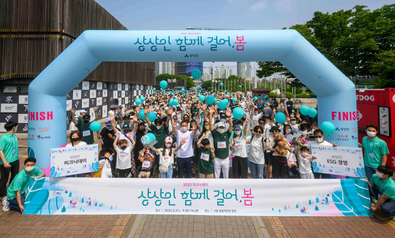 지난 5월 21일 서울 올림픽공원에서 상상인그룹 걷기프로젝트 일환으로 열린 ‘2022 상상인 피크닉데이’에서 유준원 상상인 대표와 상상인그룹 임직원 및 휠체어 사용 아동들이 함께 기념 촬영을 하고 있다.[상상인그룹 제공]