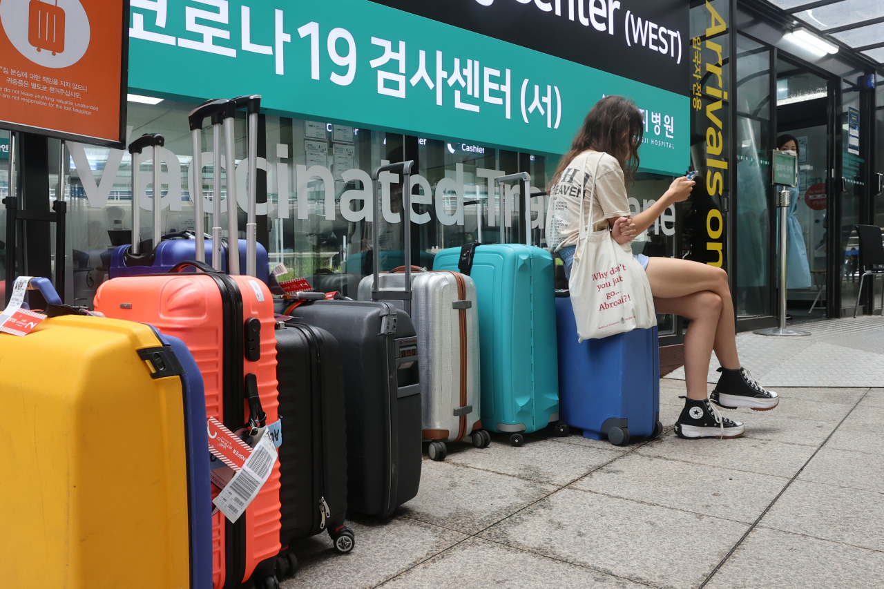 지난 7월 24일 휴가철을 맞은 인천국제공항 제1여객터미널 입국자 신종 코로나바이러스 감염증(코로나19) 검사센터 앞에 검사를 받고 있는 입국자들의 캐리어가 줄지어 놓여 있다. [연합]