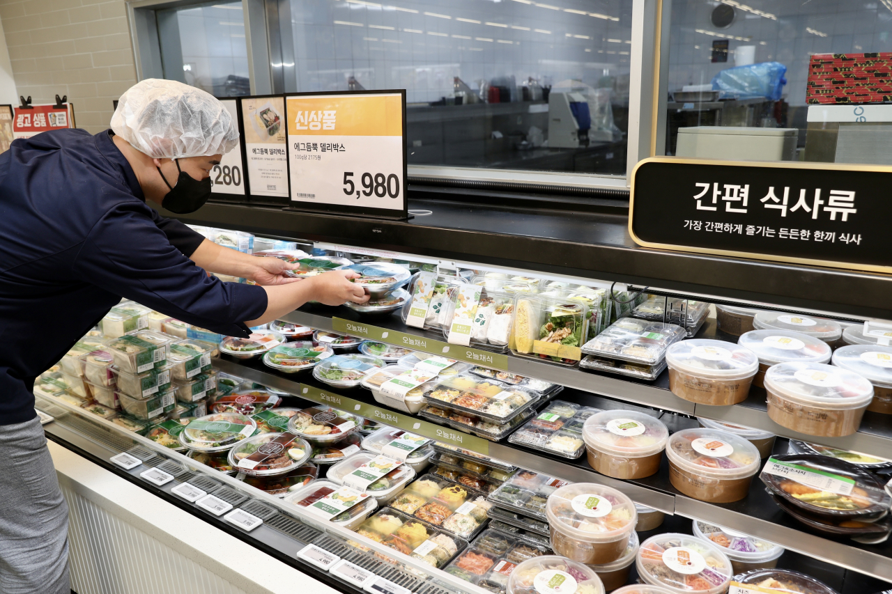 외식물가 상승과 맞물려 대형 마트의 샌드위치, 샐러드, 김밥 등 4000~5000원대의 간편식사류 매출이 크게 늘었다. 이마트 성수점 간편식사류 코너에서 직원이 제품을 정리하고 있다. [이마트 제공]