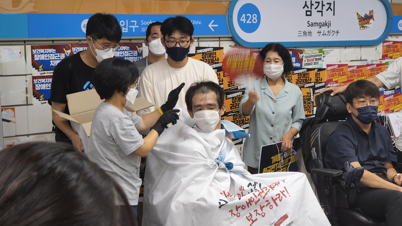 전국장애인차별철폐연대(전장연) 관계자들이 3일 서울 지하철 4호선 삼각지역 승강장에서 장애인 권리 예산 보장을 촉구하며 삭발 시위를 벌이고 있다. [연합]