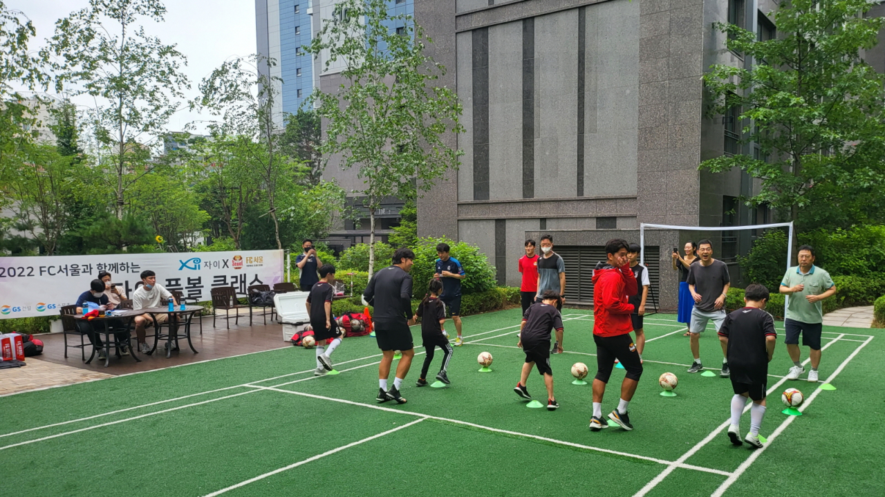 지난 7월 24일 서울 마포구 신촌그랑자이 아파트에서 진행된 ‘FC서울과 함께하는 찾아가는 풋볼클래스’ 행사에 참여한 입주민들이 축구 기술을 배우고 있다. [GS건설 제공]