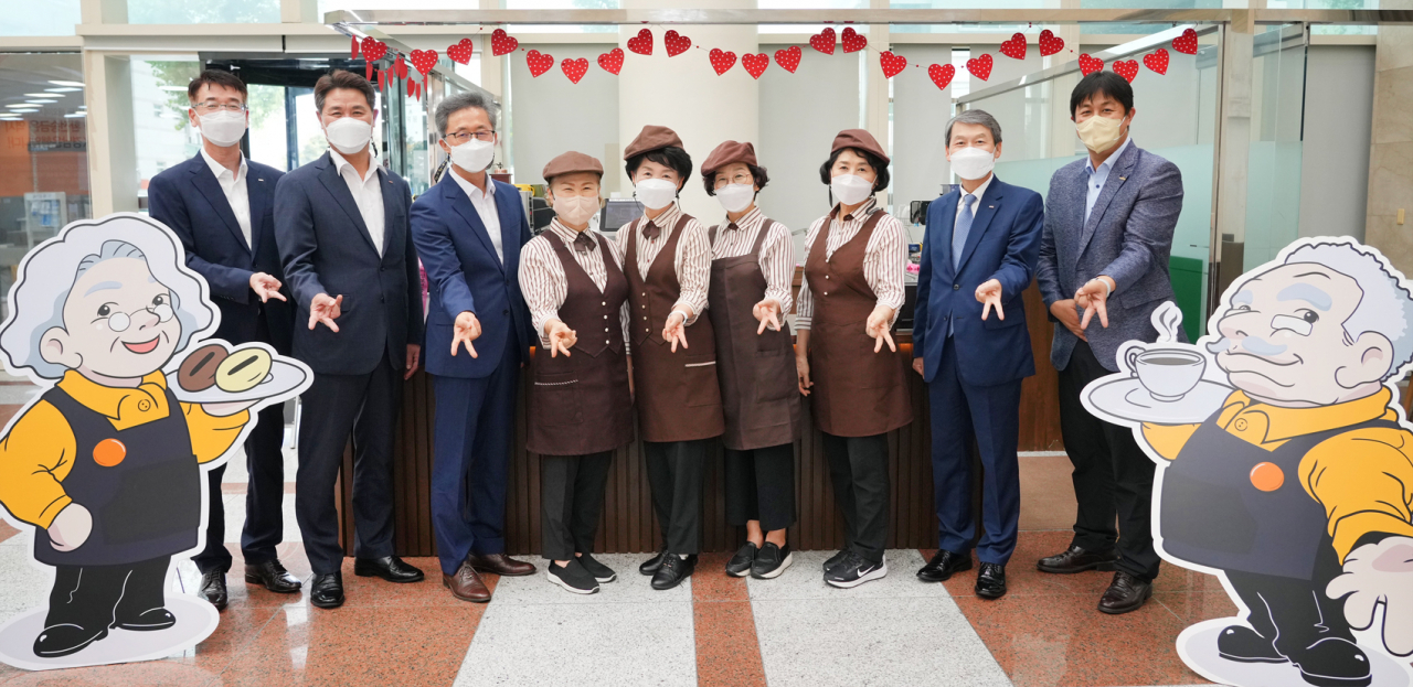 카페아리 오픈식에 참석한 BNK경남은행 김영원 그룹장(사진 오른쪽 두번째)과 카페아리 소속 어르신 그리고 경상남도 노인복지과 관계자들이 기념촬영하고 있다. [경남은행 제공]