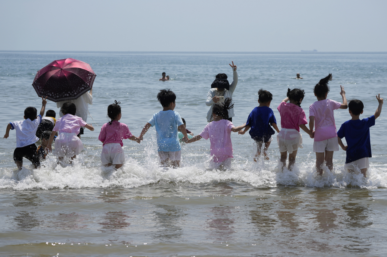 7일(현지시간) 중국 동부 푸젠성 핑탄의 대만 해협과 이어지는 해변가에서 관광객들이 보이고 있다. 중국은 이날 나흘째 대만 포위 군사훈련을 실시했다. [AP]