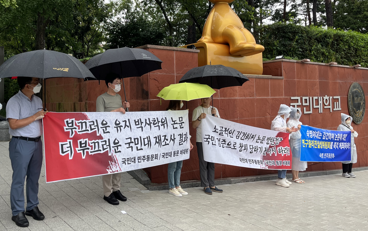 8일 국민대 정문 앞에서 국민대 동문 비상대책위원회가 윤석열 대통령 부인 김건희 여사가 2007년 쓴 박사학위 논문조사 결과에 항의하는 현수막을 들고 시위를 하고 있다. 김 여사의 석사학위 논문 표절 의혹을 살펴보고 있는 숙명여대의 민주동문회도 숙명여대에 연구윤리진실성위원회 개최를 촉구하는 현수막을 들고 동참했다. [연합]
