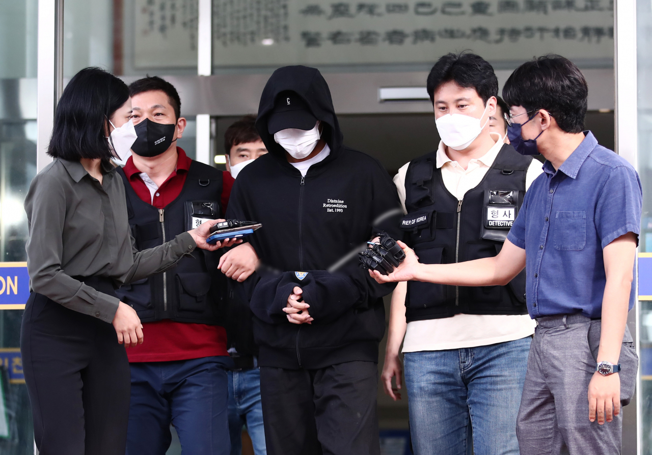 인하대 캠퍼스 내에서 여학생을 성폭행한 뒤 건물에서 추락해 숨지게 한 혐의를 받는 1학년 남학생 A씨(가운데)가 지난달 22일 검찰로 송치되는 모습. [연합]