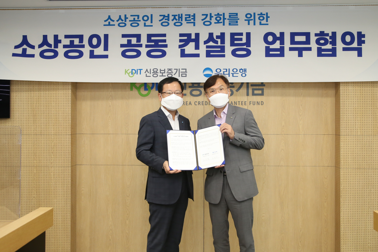 [사진=조충행 신용보증기금 이사(오른쪽)와 조병규 우리은행 부행장(왼쪽)이 9일 마포 프론트원(Front1)에서 열린 '소상공인 공동 컨설팅 업무협약'에 참석해 기념촬영을 하고 있다.]