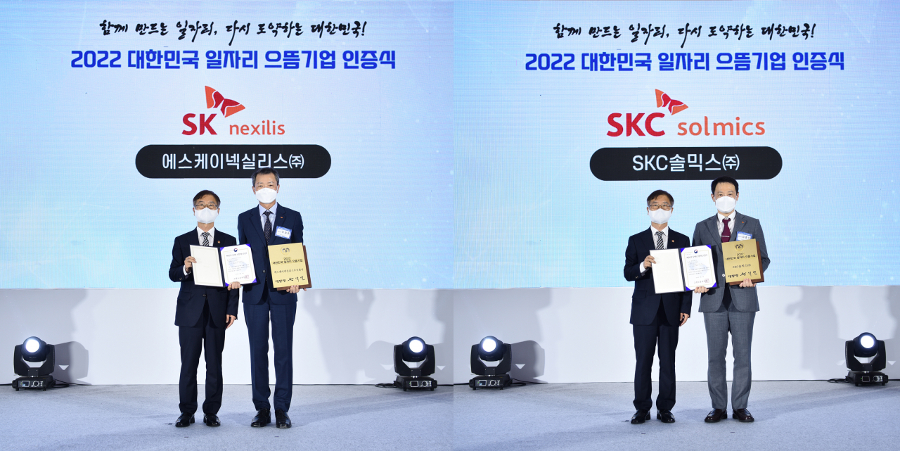 이재홍(좌측사진 오른쪽) SK넥실리스 대표와 김종우(우측사진 오른쪽) SKC솔믹스 대표가 지난 9일 열린 시상식에서 이정식(각사진 왼쪽) 고용노동부 장관과 함께 인증서와 대통령 인증패를 들고 있다. [SKC 제공]