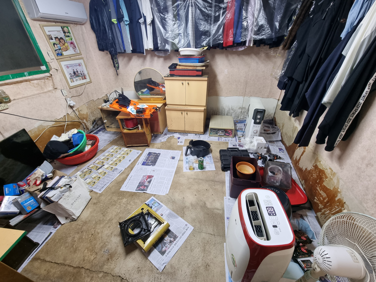 지난 9일 오후 서울 강남구 구룡마을의 한 주택 내부에 폭우로 인해 물이 들어차 젖은 탓에 바닥 곳곳에 신문이 깔려 있다. 이외에도 지폐, 옷 등에 남아 있는 물기를 말리고자 공기청정기와 선풍기가 가동된 흔적이 보인다. 김영철 기자