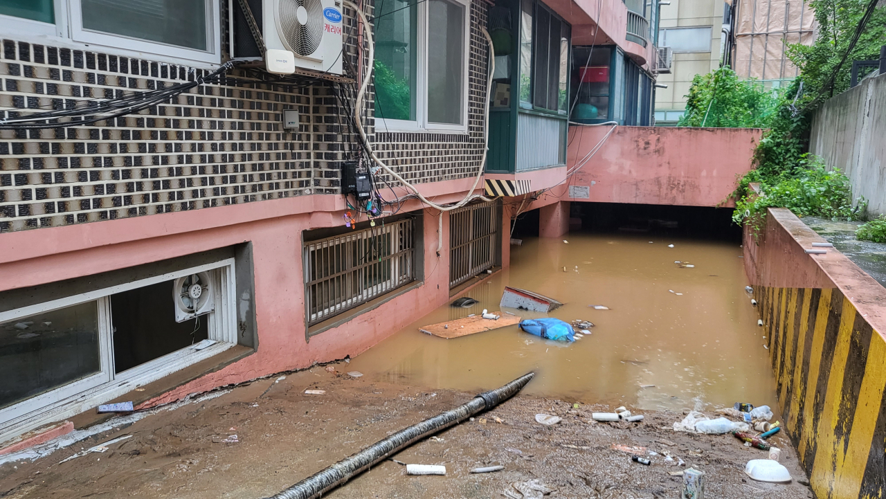 지난 8일 오후 9시 7분께 서울 관악구 부근 한 빌라 반지하에 폭우로 침수된 일가족 3명이 갇혀 신고했지만 결국 사망했다. 주민에 따르면 사고가 난 빌라 바로 앞 싱크홀이 발생해 물이 급격하게 흘러들었고, 일가족이 고립돼 구조되지 못했다. 사진은 침수된 빌라 배수작업. [연합]