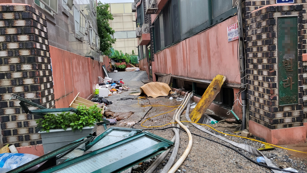 지난 8일 오후 9시 7분께 서울 관악구 부근 한 빌라 반지하에 폭우로 침수된 일가족 3명이 갇혀 신고했지만 결국 사망했다. 주민들에 따르면 사고가 난 빌라 바로 앞 싱크홀이 발생해 물이 급격하게 흘러들었고, 일가족이 고립돼 구조되지 못했다. 사진은 사고 현장. [연합]