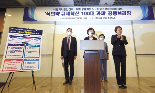 오유경(가운데) 식품의약품안전처장이 강석구(뒷줄 왼쪽) 대한상공회의소 조사본부장, 원영희(뒷줄 오른쪽) 한국소비자단체협의회 회장과 함께 11일 서울 중구 대한상의에서 열린 ‘식의약 규제혁신 100대 과제’공동브리핑에 참석해 발표하고 있다. [연합]