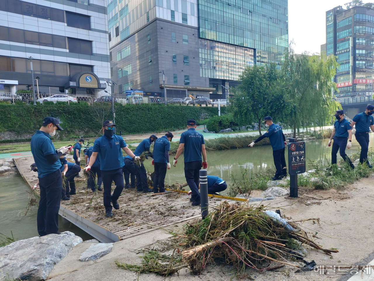 12일 서울 관악구 신림동 도림천 인근 폭우 침수 피해복구 현장에서 경찰관들이 부유물을 옮기고 있다. 김희량 기자