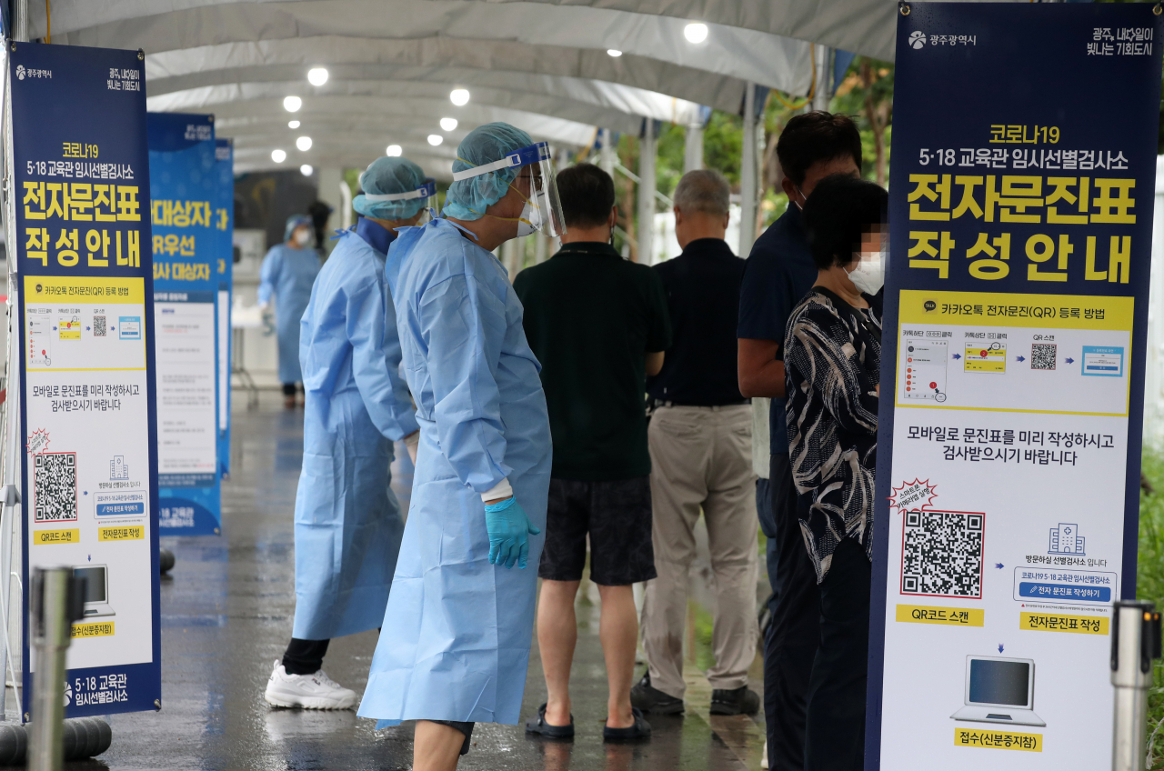 11일 오후 광주 서구 5·18민주화운동 교육관에 재설치 운영에 들어간 임시선별검사소에서 의료진이 코로나19 검사를 받으려는 시민들의 문진표 작성을 돕고 있다. [연합]