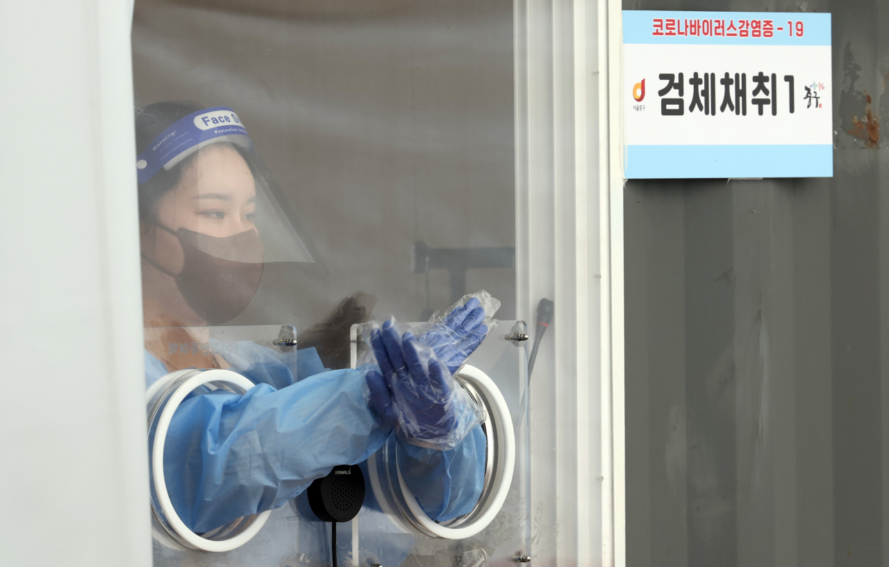 광복절 연휴인 14일 오후 서울역 선별검사소에서 한 의료진이 수신호를 하고 있다. 이날 0시 기준 코로나19 확진자는 11만9천603명이다. [연합]
