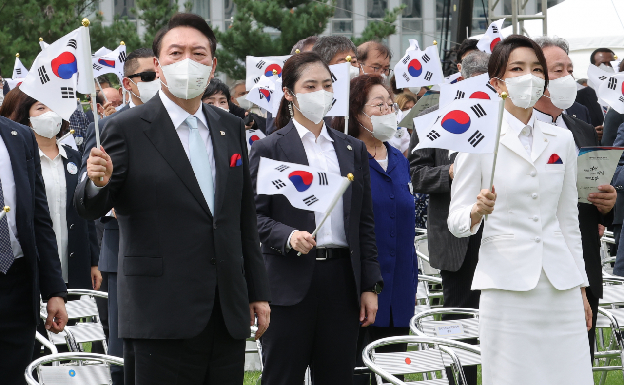 윤석열 대통령이 15일 서울 용산 대통령실 잔디마당에서 열린 제77주년 광복절 경축식에서 부인 김건희 여사와 함께 태극기를 흔들고 있다. [연합]