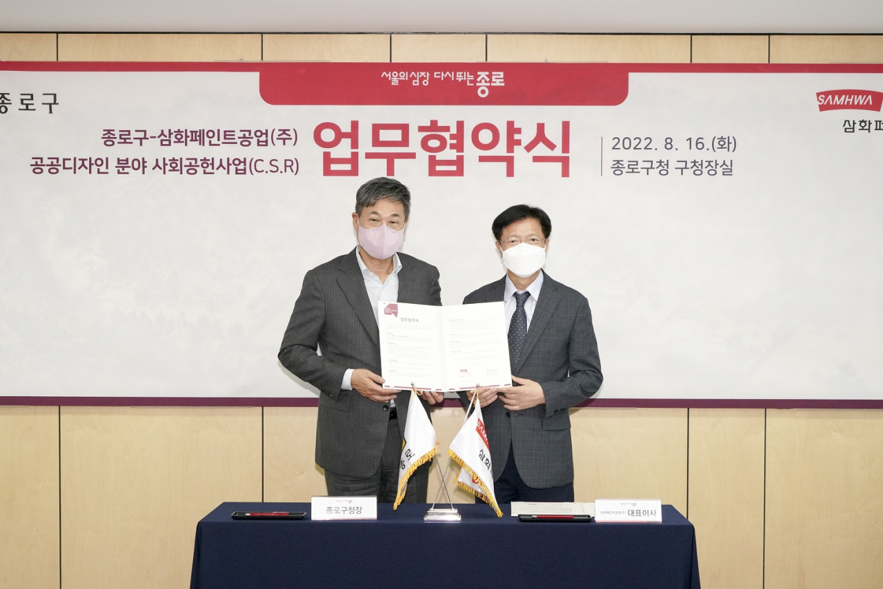 정문헌 종로구청장(왼쪽)이 서울 종로구청 구청장실에서 16일 열린 삼화페인트공업과의 업무협약식에서 협약서를 들고 있다. [종로구 제공]