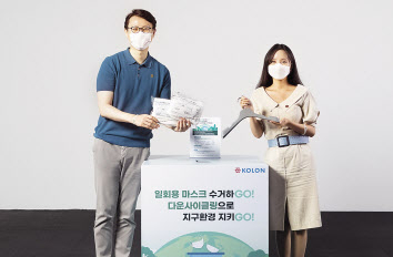 코오롱그룹 임직원들이 사용후 폐마스크를 수거함에 직접 모아 만든 재활용 옷걸이를 마스크 수거함 앞에서 소개하고 있다. [코오롱 제공]