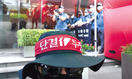 17일 서울 강남구 하이트진로 본사 사옥에서 민주노총 공공운수노조 화물연대가 운송료 인상을 요구하며 시위하고 있는 가운데 노조 뒤편으로 본사 입구를 경찰병력이 막고 있다.임세준 기자